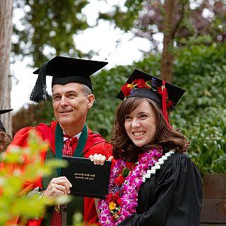 约翰·麦维和他的女儿在毕业典礼上微笑的照片